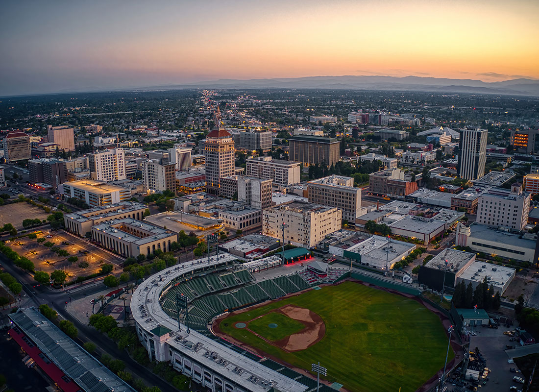 Fresno, CA - Aerial View of Commercial Buildings and a Stadium in Downtown Fresno California in the Early Evening with a Colorful Sky